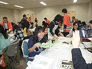 出来栄えを笑顔で写真撮影する学生